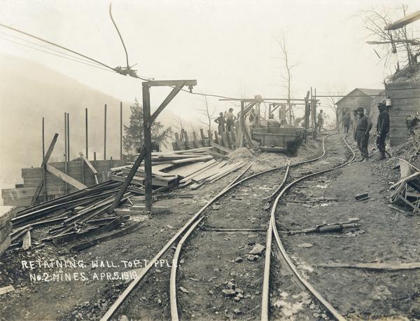 Workers building a retaining wall to "P. tipple" of the no. 2 mine. Benham was a "company town" created by International Harvester for the workers of the Wisconsin Steel Company. Wisconsin Steel was a subsidiary of International Harvester and operated coal mines at Benham.