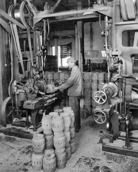 Factory worker at International Harvester's Weber Works working on wooden wagon wheel hubs.