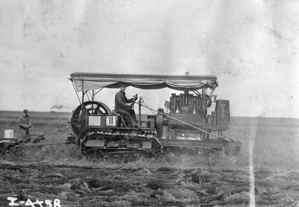 Man plowing with a Holt crawler tractor, no. 1609, at the Winnipeg tractor contest in Canada. The tractor was built by the Holt Manufacturing Company of Stockton, California.