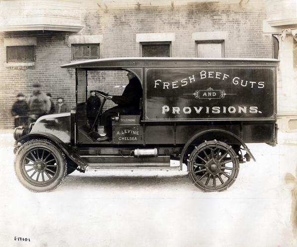Driver delivering "Fresh Beef Guts and Provisions" in an International Model H 1 1/2 ton truck. The truck was owned by A. Levine. The Model H was produced from 1915-1923.