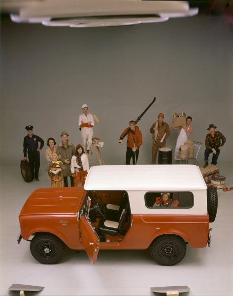 Color advertising photograph depicting people in various professions and walks of life surrounding a new International Scout.