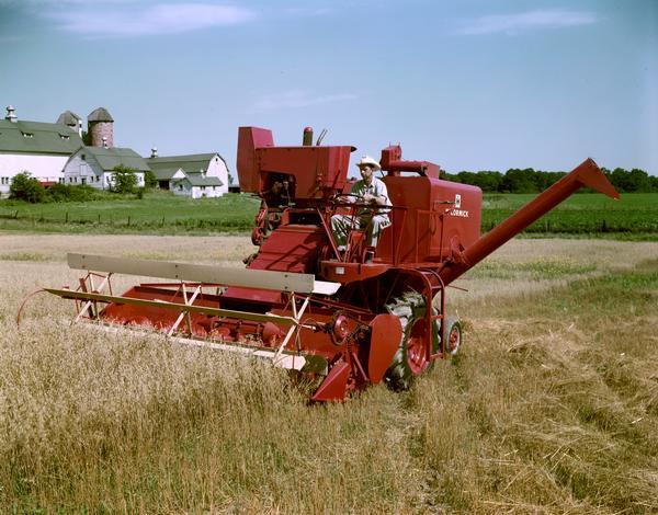 Farmer harvesting wheat with a McCormick combine (harvester-thresher) at Hinsdale Farm, near International Harvester's experimental farm.