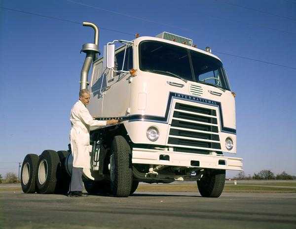 Color photograph of an engineer attaching a Transtar nameplate to an International semi-truck during testing.