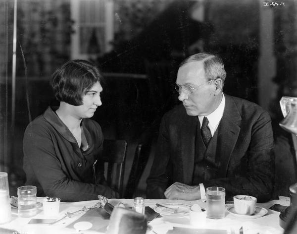 Alexander Legge (1866-1933) sitting with Miss Florence Melchert, an "entertainment" provided by International Harvester for 4-H Club  delegates. Miss Melchert was the winner of the 4-H Club's "Moses Trophy" for leadership. Legge was president of International Harvester Company from 1922 to 1929. He was vice chairman of the War Industries Board during World War I and later appointed chairman of the Federal Farm Board by President Hoover in 1929. He became president of International Harvester again in 1931 and remained in that position until his death in 1933.