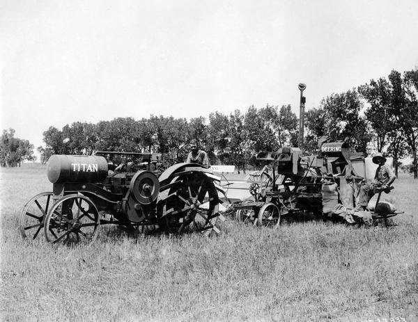 Men are posing in a field with a Titan 10-20 tractor and an early (experimental?) Deering harvester-thresher (combine).