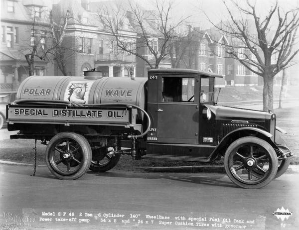 International Model SF-46 2 ton motor truck equipped with 500 gallon oil tank and power take-off pump. The truck was owned by the Polar Wave heating oil company. The sign painted on the tank reads: "Polar Wave" and the sign painted on the side of the truck reads: "Special Distillate Oil." There is a Polar Bear painted on the tank in the center holding a sign that reads: "We Have Come To Stay." The tires are Goodyear Super-Pneumatic Cushion.