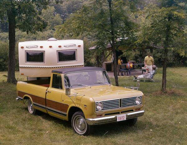 Color advertising photograph of a family of four camping out with an International 1110 Custom pickup and Hy-Lander trailer home.