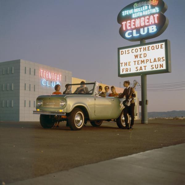 Color advertising photograph of teenagers and band members gathered in and around an International Scout pickup at the Teenbeat Club owned by Steve Miller and Keith Austin. Known for the Teenbeat Club Television Program sponsored by Pepsi Cola, the club was the centerpiece of a highly rated show which aired in prime time, 5-6 PM, each Saturday from 1962 through 1966 on KLAS TV in Las Vegas. The marquee announces a show by the Templars.