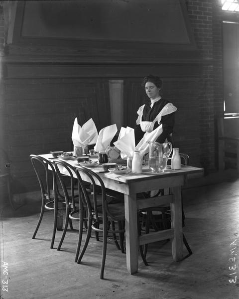 Waitress tending a table in the dining room of the McCormick Works Club House.