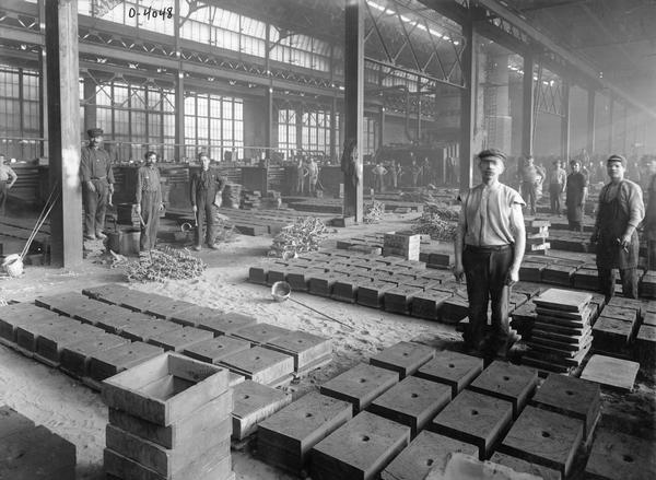 Men standing among molds in a section of the malleable foundry at International Harvester's Osborne Works. The factory was owned by the D.M. Osborne Company until 1903, when it was purchased by International Harvester. The factory was later known within the company as the "Auburn Works." It was located at 5 Pulaski Street.