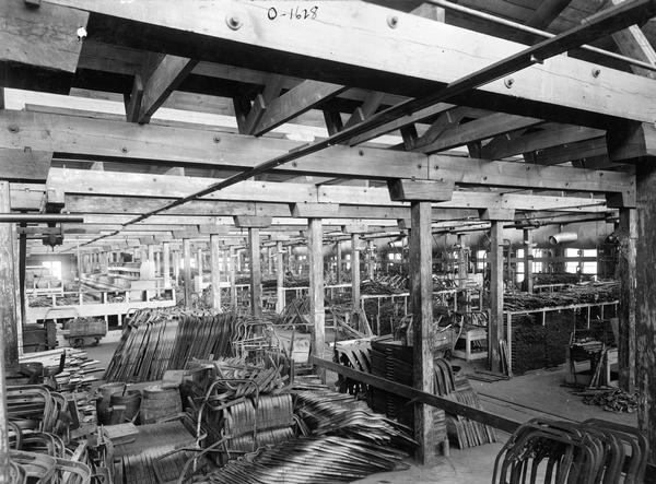 Stacks of implement parts in a section of the "harrow room" at International Harvester's Osborne Works. The factory was owned by the D.M. Osborne Company until 1903, when it was purchased by International Harvester. The factory was later known within the company as the "Auburn Works." It was located at 5 Pulaski Street.