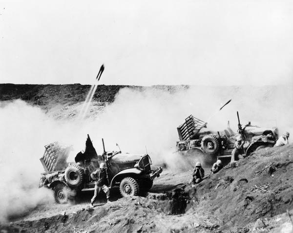 Soldiers firing rockets from two International M-2-4 launch vehicles during combat operations in Iwo Jima.