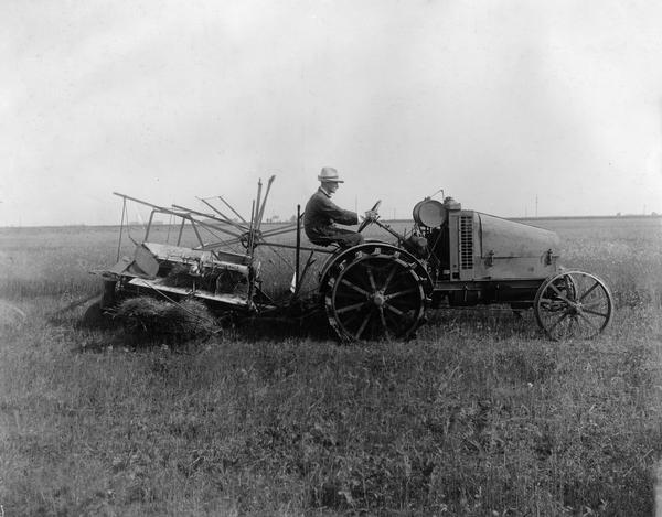 Man pulling a McCormick binder with an International 8-16 tractor.