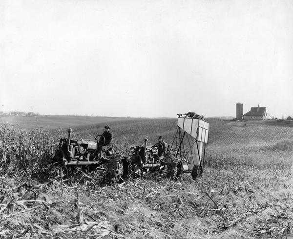 Farmers using Farmall tractors and a corn-picker with overhead grain tank on the Callens farm.