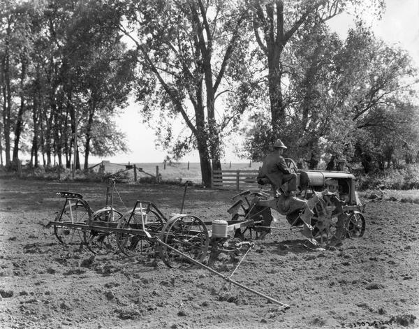 Farmer planting corn with a Farmall tractor and corn planter on the farm of D.H. Hummell.