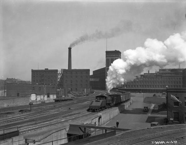 Elevated view of steam engine pulling railroad cars in the railroad yard at International Harvester's McCormick Works.