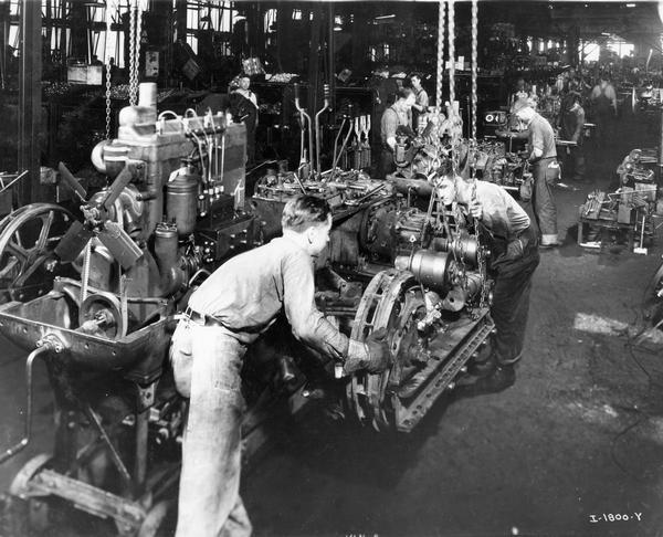 Factory workers with TracTractors (crawler tractors) on the assembly line at International Harvester's Tractor Works.