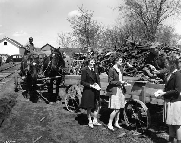 Sales girls (L to R): Patsie Anderson, Margaret Hatche, and Leone Owens distribute war bonds and stamps to farmers and other townspeople during a W.W. II scrap drive. The drive was held during "MacArthur Week." 182 farmers participated in the drive that brought in over 105 tons of scrap metal to this town of less than 500.
