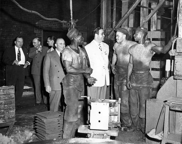"Harvest of Stars" radio and stage personality James "Jimmie" Melton talking with African American workers during a tour of an International Harvester's Indianapolis Works.