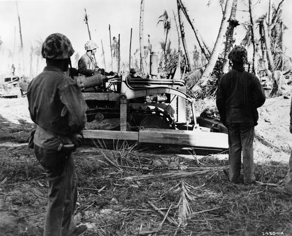 Marines using an International TD-9 diesel TracTracTor (crawler tractor) and bulldozer to hunt Japanese soldiers on Namur, Kwajalein Atoll, Marshall Islands. Original caption reads: "The Jap pillboxes were buried so well only a bulldozer could rout them."