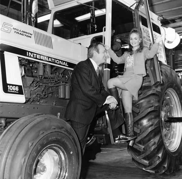 Original press release photo caption reads: "In special ceremonies at International Harvester's Farmall Plant, Rock Island, IL, Stanley F. Lancaster, vice president, marketing, Agricultural/Industrial Equipment Division, Chicago, and local beauty, Valerie Robb, 22, hail production of the company's record 5,000,000th tractor on (Friday, Feb. 1). IH is the first tractor manufacturer in the world to claim this distinction and marked the event with an assembly line commemorative celebration." The tractor is a Farmall 1066.