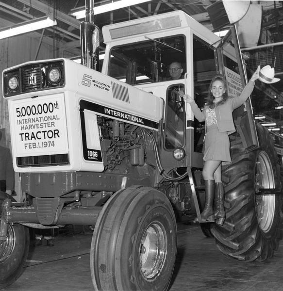 Press release photograph of female model, Valerie Robb, posing on the 5,000,000th International Harvester tractor to roll off the assembly line on Feb. 1, 1974. The tractor is a Farmall 1066.