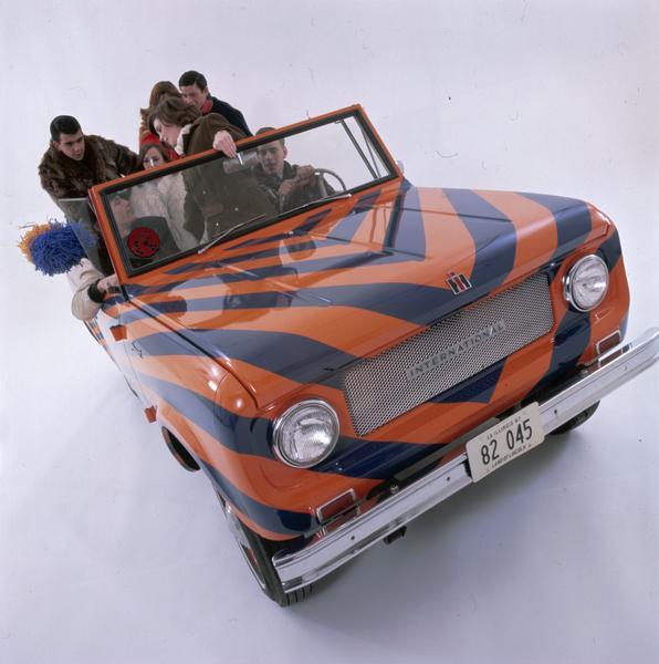 Color advertising photograph of a 1967 International Scout pickup painted in the colors of the University of Illinois, apparently carrying college football fans.