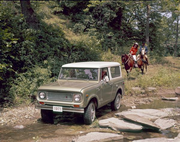 Color advertising photograph of a couple in a 1971 International Scout pickup crossing a small creek, as another couple is following behind on horseback.