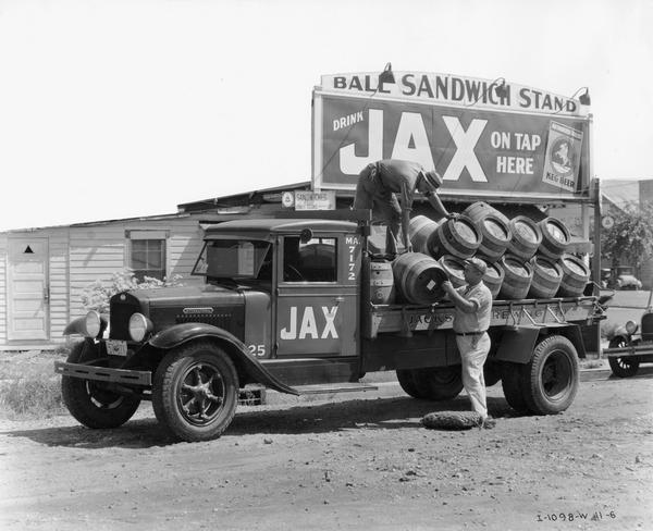 Men unloading barrels of Jax beer in front of the Ball Sandwich Stand in rural Louisiana. Jax beer was made by Jack's Brewing Company.