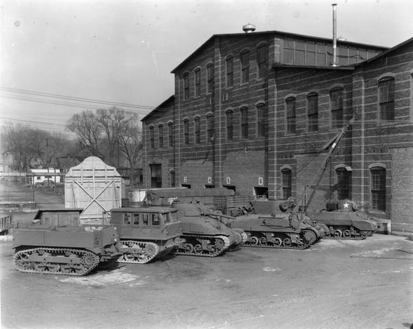 U.S. military equipment lined up outside International Harvester's Bettendorf Works. Pictured left to right are a M-5 prime mover (1st design), a M-5 prime mover (last design), a M-5 tank, a tank retriever, and a M-3 tank.