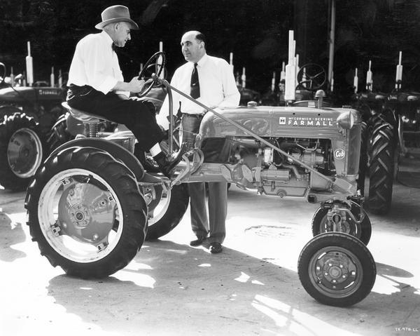 Mr. W.A. Salzmann, general superintendent, congratulating works manager Mr. J.E. Harris (seated atop tractor) on completion of the first Farmall Cub tractor at International Harvester's Louisville Works.