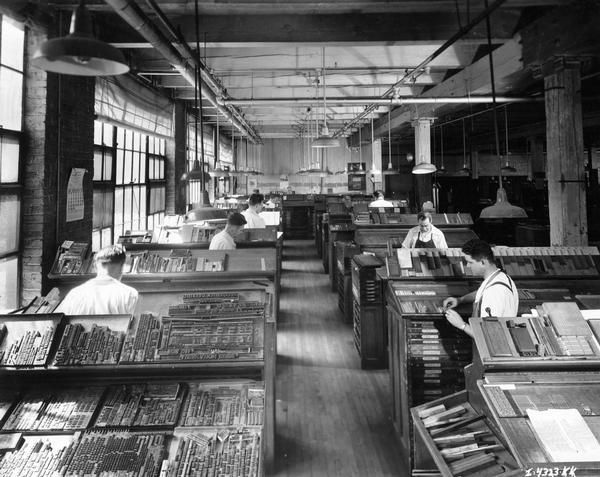 Workers setting type inside the Harvester Press typesetting room.