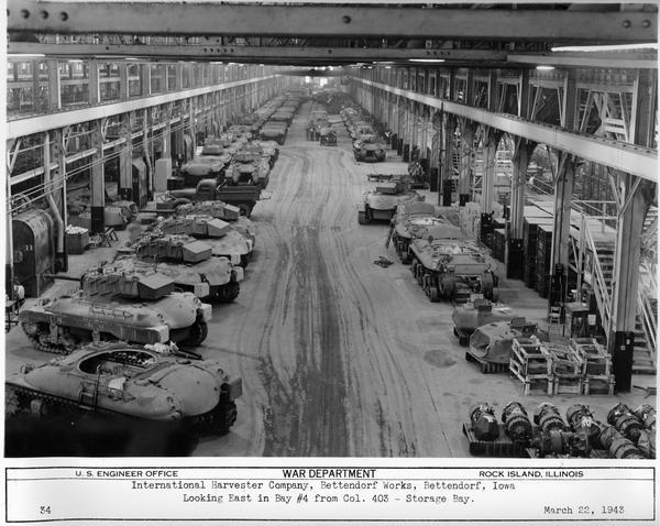 Partially assembled and completed M-7 tanks at International Harvester's Bettendorf Works. Original caption reads: "Looking East in Bay #4 from Col. 403 - Storage Bay."