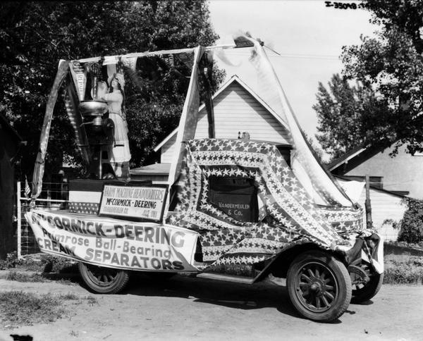 International truck owned by the Vandermeulen Company adorned with starred banners and advertisements for McCormick-Deering cream separators. The truck likely took part in a 4th of July parade. Vandermeulen Company was an International Harvester dealership.