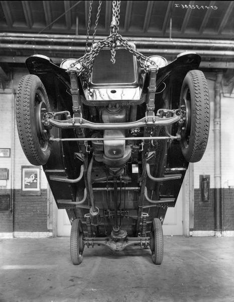 View of an International Six Speed Special truck in the shop with the front end suspended by chains.
