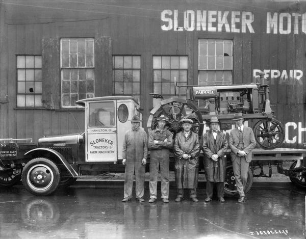 Otto, Herbert, Eugene, Wilbur and Kenneth Sloneker standing in front of an International truck loaded with a Farmall Regular tractor. The brothers were partners in Sloneker Tractors and Farm Machinery, an International Harvester dealership.