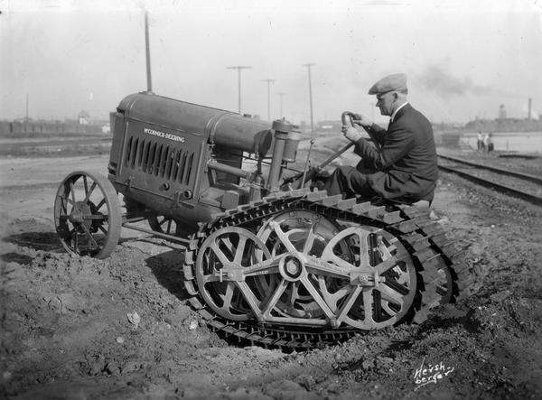 Man driving a McCormick-Deering industrial tractor with a rear crawler track attachment produced by the moon Track Company of San Diego, California. Railroad tracks are in the background on the right. This photograph was taken by B. Hershberger of the International Harvester Advertising Department in Los Angeles.