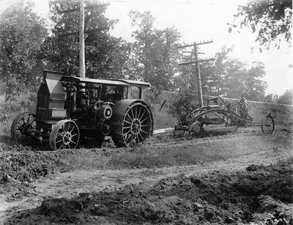 Road workers leveling road with International Mogul 45 or 30-60 kerosene tractor and Austin Mammoth Steel Reversible Road Machine.