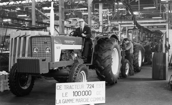Director of Manufacturing of International Harvester France, R. Averay, driving an International 724 tractor off the assembly line in France. The tractor was the 100,000 International tractor produced in the European Common Market.