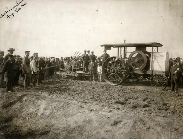 Crowd gathered in a field at Ekaterinburg  (Ekaterinoslaw) to witness a demonstration of the first International Harvester tractor shipped to Russia. The tractor is pulling a breaking plow.