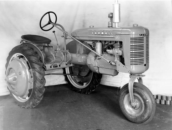 Engineering photograph of an experimental McCormick-Deering Farmall B tractor with 32" rear wheels and a single front wheel. A white backdrop is in the background. Three-quarter view towards front right.