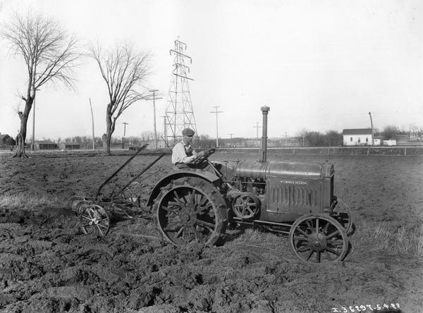 Carl Seamonson plowing a field with a McCormick-Deering 10-20 tractor and plow.