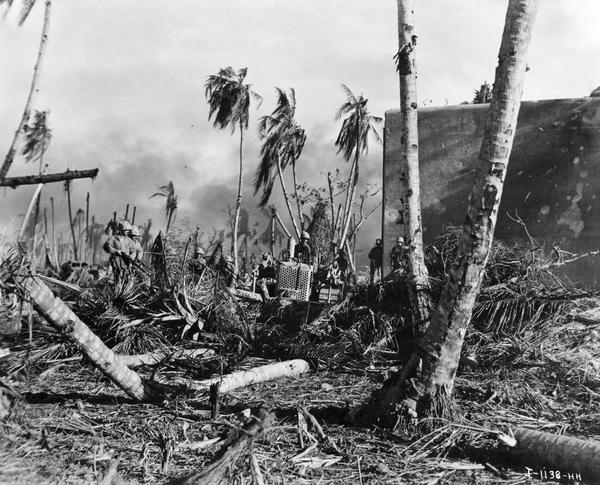 U.S. Marines using International crawler tractors (TracTracTors).  The photo caption reads:  "Marines 'mopping up' on Namur Island in the Marshalls use their bulldozers to flush Jap snipers out of debris near the air ship."  These International crawler tractors are an active combat weapon, as well as an important piece of construction equipment. Official U.S. Marine Corps Photograph.