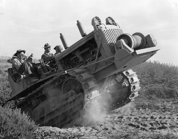 Men, possibly soldiers, driving an International crawler tractor (TracTracTor). The photograph was taken by F.J. Delaney for International Harvester Company.