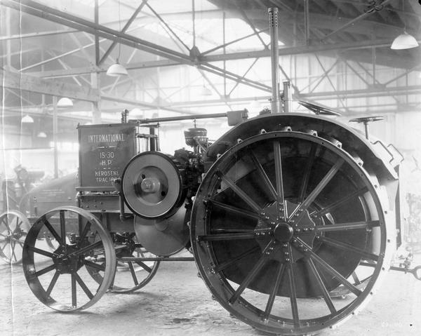 Left side view of an International 15-30 H.P. kerosene tractor on a factory or warehouse floor.