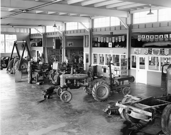Farmall tractors and crawler tractors (TracTracTors) in the service shop of an International Harvester prototype dealership building owned by Allied Equipment Co.