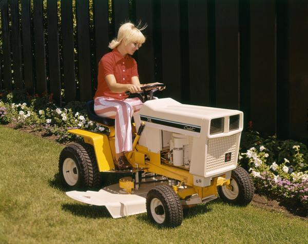 Color advertising photograph of a woman mowing a lawn with a Cadet 76 lawn tractor.