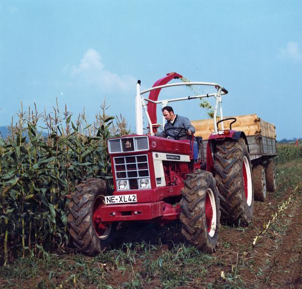 Man harvesting corn with International 1046 tractor in Germany.