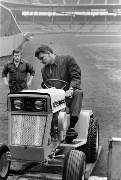 Man driving an International Cub Cadet at Wrigley Field. The lawn tractor was used for grounds keeping at Wrigley Field, home of the Chicago Cubs.