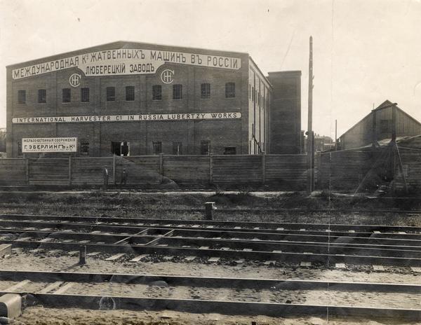 Exterior of International Harvester's Lubertzy Works (factory) in Russia. Railroad tracks are in the foreground.